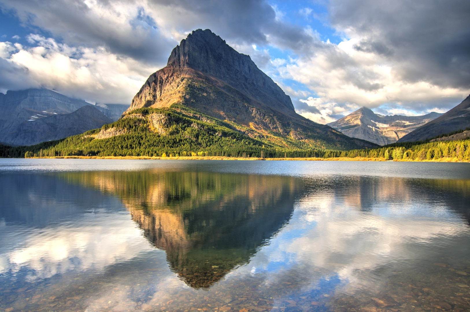 An image depicting the trail Feather Plume Cutoff Trail from Swiftcurrent Lake and its surrounding area.