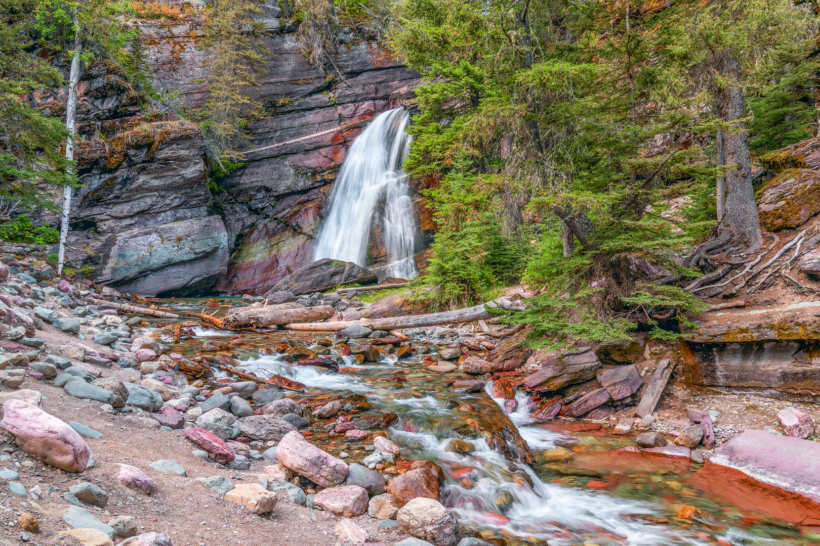 An image depicting the trail Baring Falls via Siyeh and Piegan Pass and its surrounding area.
