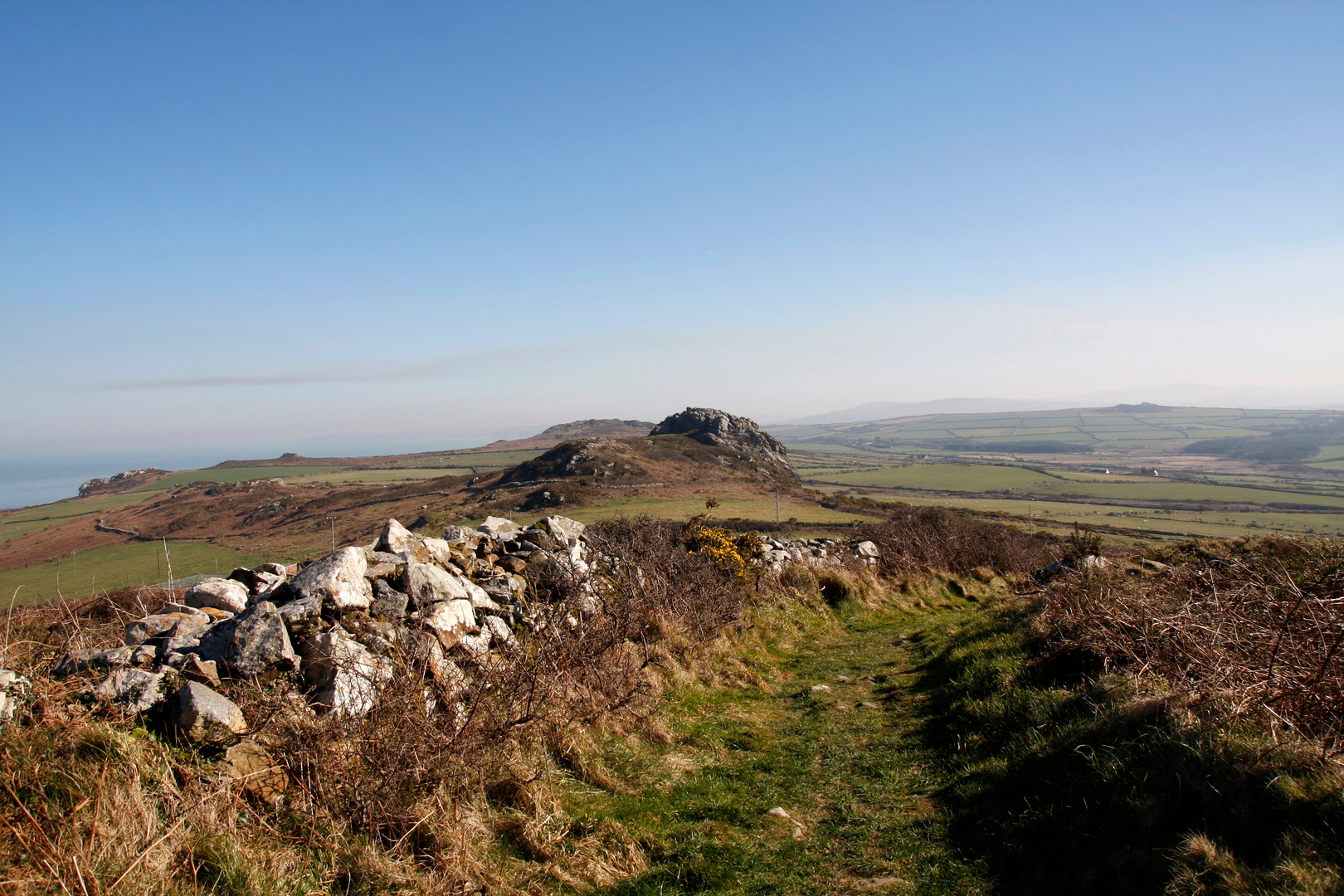An image depicting the trail Pwll Deri towards Penbwchdy and its surrounding area.