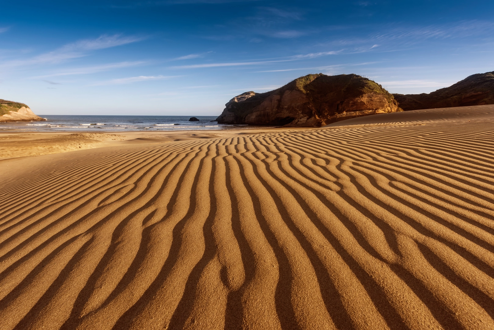 An image depicting the trail Wharariki Beach via Wharariki Road and its surrounding area.